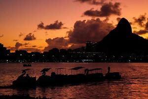 rio de janeiro, rj, brasilien, 2022 - tretboote in der silhouette bei sonnenuntergang an der lagune von rodrigo de freitas foto