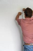 senior woman messen wand mit maßband wohnung reparieren. reifer ehemann renovieren haus foto