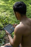 junger mann erklärt das zeichnen auf seinem tablet, während er chakra-, yoga- und meditationsunterricht gibt, mexiko foto