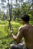 Blick auf einen Mann, der einen virtuellen Fitnesskurs mit einer Gruppe von Menschen zu Hause bei einer Videokonferenz durchführt. Fitnesstrainer, der Online-Yoga-Kurse nimmt foto