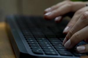 arbeiten zu hause mit laptop frau schreibt einen blog. weibliche hände auf der tastatur foto