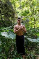 Junger Mann, der auf einer Treppe in einem Wald, Mexiko, meditiert foto