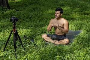 Blick auf einen Mann, der einen virtuellen Fitnesskurs mit einer Gruppe von Menschen zu Hause bei einer Videokonferenz durchführt. Fitnesstrainer, der Online-Yoga-Kurse nimmt foto