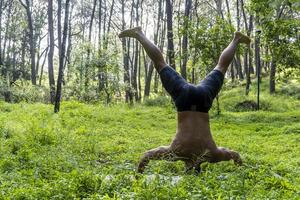 lateinamerikanischer mann macht yogahaltung, yogahaltung, biene rückwärts prsthatah brahmara, wald foto
