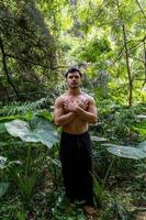 Junger Mann, der auf einer Treppe in einem Wald, Mexiko, meditiert foto