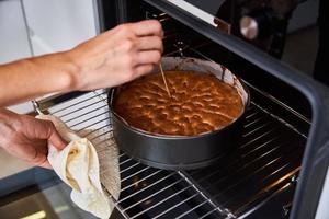 Hausfrau bereitet Kuchen in der Küche zu. hausgemachter Kuchen backen im Ofen foto