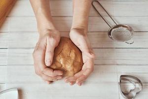 Frau knetet Teig mit den Händen in der Küche foto