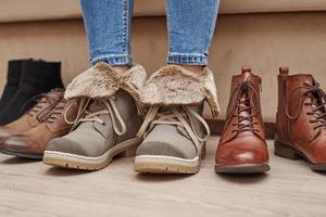 Frau wählt bequeme Schuhe aus einer Reihe verschiedener Paare foto
