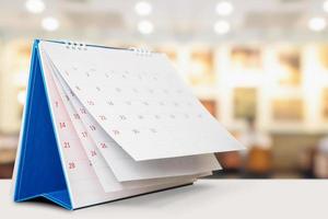 tischkalender auf dem tisch mit unscharfem bokeh-hintergrundtermin und geschäftstreffenkonzept foto