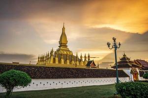 laos reisewahrzeichen, goldener chedi, wat phra that luang bei sonnenuntergang in vientiane foto