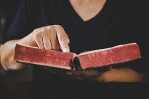 junge frau person hand halten heilige bibel mit studium zu hause. erwachsenes weibliches christliches lesebuch in der kirche. mädchen lernen religion spiritualität mit beten zu gott. Konzept des Studentenbildungsglaubens. foto