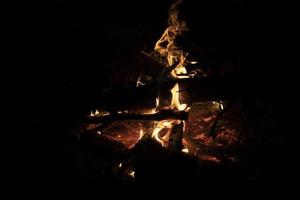 Lagerfeuer im Dunkeln. Flammen in der Nacht. brennendes Holz. Campingdetails. foto