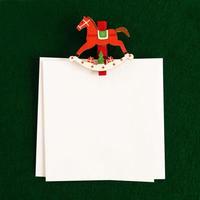 zwei weiße Blätter mit rot-weißem Holzstift auf grünem Hintergrund für Weihnachtsgrüße. Platz kopieren. foto