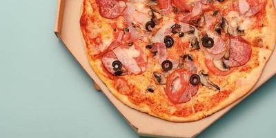 Hintergrund mit Pizza. leckere Pizza mit Käse, Speck, Tomaten und Oliven. foto