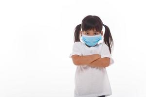 asiatisches kleines mädchen, das atemschutzmaske trägt, um den ausbruch des coronavirus zu schützen foto