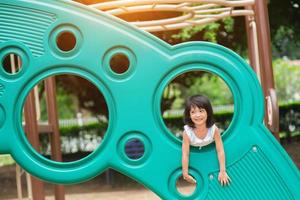 aktives kleines Mädchen auf dem Spielplatz foto