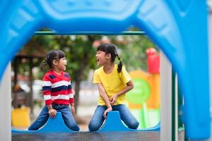 Süße kleine Mädchen Geschwister amüsieren sich an sonnigen Sommertagen auf dem Spielplatz im Freien foto