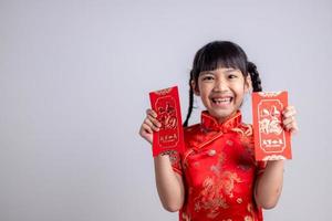 chinesisches babymädchen, das sich traditionell mit einem fu verkleidet, bedeutet glücklichen roten umschlag foto