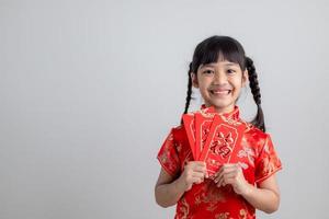 frohes chinesisches neujahr. lächelnde asiatische kleine mädchen, die roten umschlag halten foto