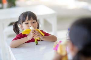 asiatische kinder in der kantine beim mittagessen oder frühstück haben spaß foto