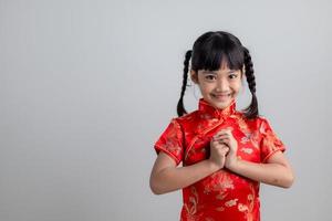 frohes chinesisches neujahr. kleine asiatische Mädchen mit Glückwunschgeste foto