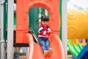 aktives kleines Mädchen auf dem Spielplatz foto