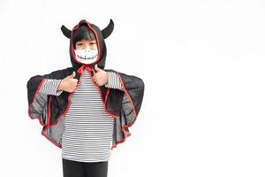 Asiatisches kleines Mädchen in einem Halloween-Kostüm in einer medizinischen Maske. halloween mit sicherheitsmaßnahmen von covid-19 foto