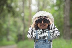 glückliches Kind, das nach vorne schaut. lächelndes Kind mit dem Fernglas. reise- und abenteuerkonzept. Freiheit, Urlaub foto