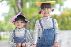 süße asiatische kinder, die ein buch auf dem tisch lesen foto