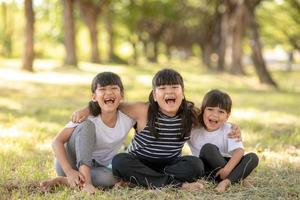 gruppe von kindergartenkindern freunde arm herum und lächeln spaß mit sonnenuntergang foto