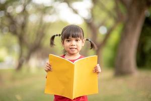 hübsches mädchen das kleine mädchen freut sich über das buch foto