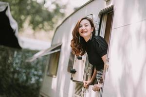 glückliche schöne hübsche asiatische frau durch wohnmobilfenster foto