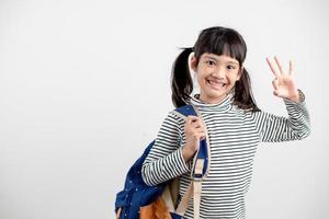 Porträt eines asiatischen Kindes in Schuluniform mit Schultasche auf weißem Hintergrund foto