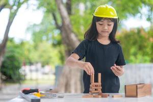 asiatische mädchenkinder, die als ingenieurhelm spielen, lächeln und sind am wochenende glücklich. foto