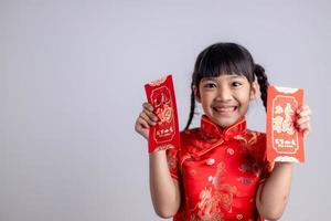 chinesisches babymädchen, das sich traditionell mit einem fu verkleidet, bedeutet glücklichen roten umschlag foto