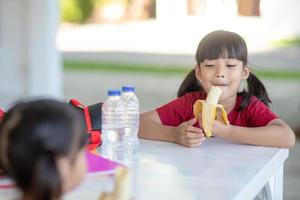 asiatische kinder in der kantine beim mittagessen oder frühstück haben spaß foto