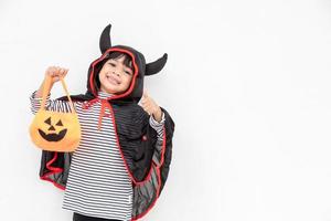 Lustiges Halloween-Kind-Konzept, kleines süßes Mädchen mit Kostüm-Halloween-Geist beängstigend, das er orangefarbenen Kürbis-Geist auf der Hand hält, auf weißem Hintergrund foto