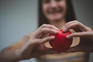 weibliche hände, die rotes herz halten, welttag der psychischen gesundheit und weltherztag, lebens- und krankenversicherung, soziale verantwortung von csr, organspende foto