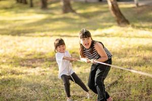 Kinder spielen Tauziehen im Park auf Sunsut foto