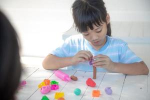 asiatische kinder spielen mit tonformen und lernen spielerisch foto