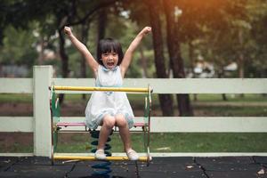 glückliche süße kinder, die spaß auf dem spielplatz haben foto