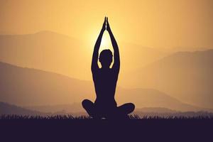 silhouette junge frau praktizieren yoga auf dem muontain bei sonnenuntergang.vintage farbe foto