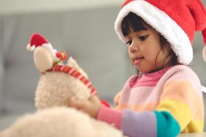 frohe feiertage süßes kleines kind öffnungsgeschenk. Das Mädchen freute sich über das Geschenk. foto