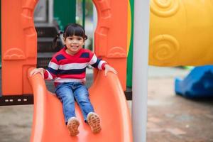 aktives kleines Mädchen auf dem Spielplatz foto