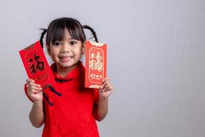 chinesisches babymädchen, das sich traditionell mit einem fu verkleidet, bedeutet glücklichen roten umschlag foto