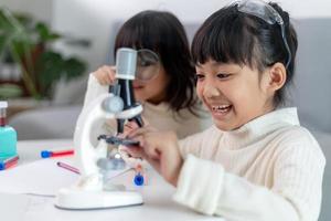Junge Mädchen spielen wissenschaftliche Experimente für den Heimunterricht foto