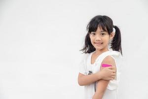 asiatisches kleines mädchen, das seinen arm zeigt, nachdem es geimpft oder geimpft wurde, kinderimmunisierung, covid delta-impfkonzept foto
