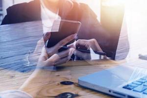 Geschäftsfrau arbeitet mit Laptop-Computer, Tablet und Smartphone im modernen Büro mit virtuellem Symboldiagramm im Modernoffice im Morgenlicht foto