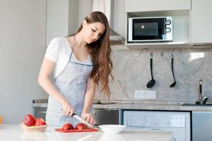 junge Frau bereitet und schneidet roten Apfel auf Schneidebrett. gesundes essen kochen. foto