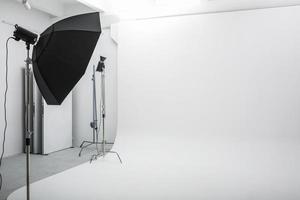 innenraum des hellen raumes des fotostudios mit großem weißem cyclorama mit beleuchtungsausrüstung foto